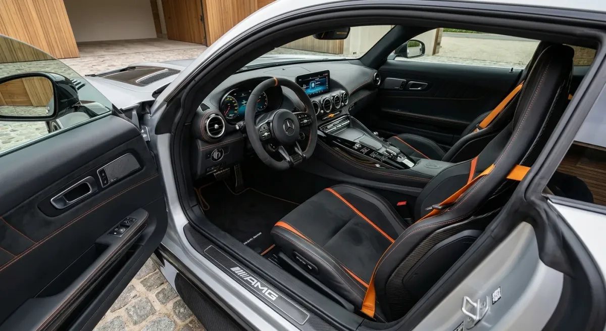 Interior europeo del AMG GT Black Series con asientos baquet, microfibra negra y costuras naranjas.