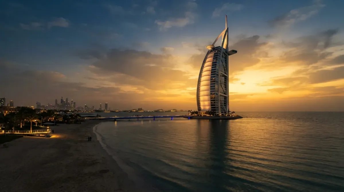El Burj Al Arab de Dubái iluminado al atardecer, destacando su fachada restaurada frente al golfo Pérsico.