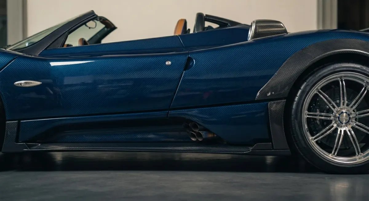 Vista lateral detallada del Pagani Zonda HP Barchetta, mostrando la rueda trasera carenada y el diseño de la carrocería sin techo.